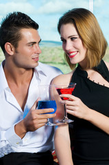 Beautiful couple having a cocktail or a drink in a bar