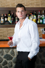 Beautiful man having a drink in a bar
