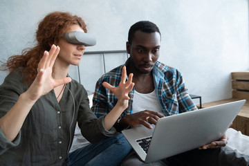 African man and red-haired woman having fun in glasses of virtual reality