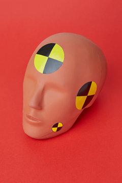 Crash test dummy head on red background