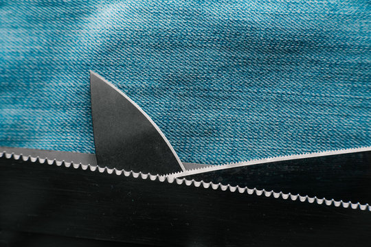 Shark concept made of knives - fin above the sea waves