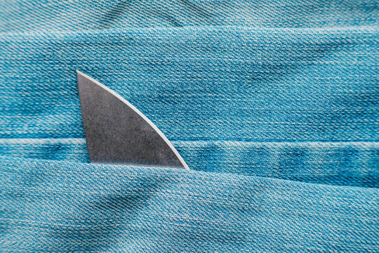 Shark concept made of knives - fin above the sea waves