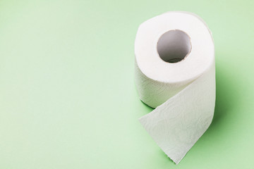 Toilet paper roll on green background with copy space