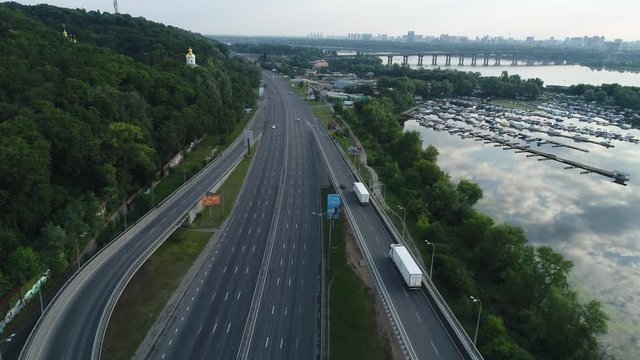 Darnitsky bridge over the Dnieper River. Ukraine city Kiev. Video from the drone. Two white trucks pulls off the bridge towards the city center