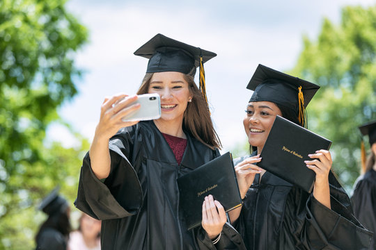 Grad: Two Friends Take Photo With Diplomas