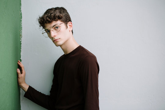 Serious young man posing on white and green background