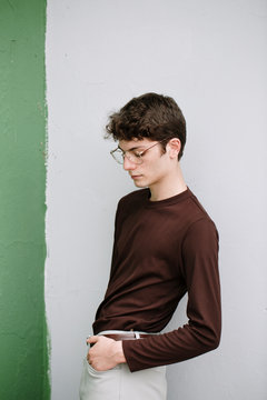 Serious young man posing on white and green background
