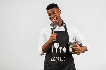 Time to cook! African american man in white shirt and apron, chef cook, comic style with soup ladle and pan. Singing while cooking