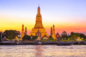 Naklejka premium Wat Wat Arun temple in front of Chao Phraya river in Bangkok at dusk. ThailandArun temple in front of Chao Phraya river in Bangkok at dusk. Thailandv