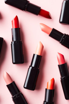 Background of lipstick tubes on pink surface