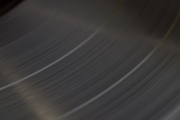 Black vinyl plate with visible music tracks on it, macro, selective focus.