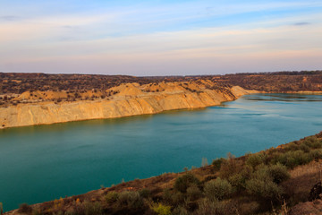 View of a lake with sandy shores in flooded sand quarry