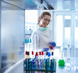 Biologist putting chemical bottles in incubator