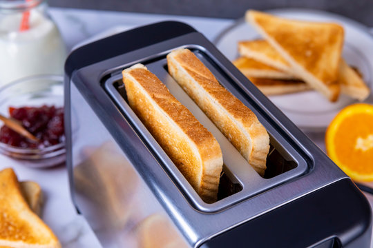 Slices of toast coming out of the toaster for healthy breakfast
