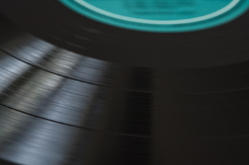 Revolving black vinyl record, selective focus.