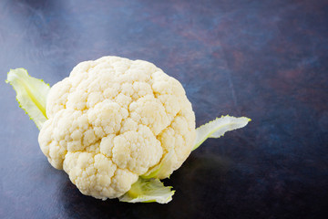 Cauliflower on dark background. Organic cauliflower on black background. Vegan healthy food....