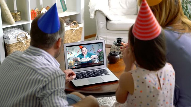 A family with a child congratulating a grandmother on her birthday using a video call. Home quarantine, social distancing, self isolation.