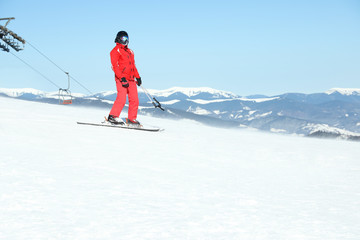 Male skier on snowy slope in mountains. Winter vacation