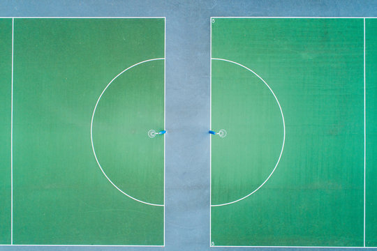 Aerial views over green hard court netball courts and nets