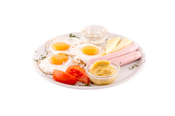 Three fried eggs garnished with cheese, ham and tomatoes. Photo taken on a white background. Dish of Montenegrin cuisine. Suitable for the restaurant menu.