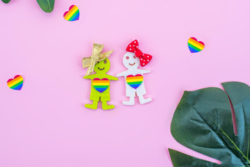 LGBT figures of people. Two figures of women show unconventional orientation. Marriage and family, couple. Pink background.