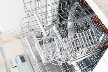 opened new empty dishwasher machine in the kitchen - Powered by Adobe
