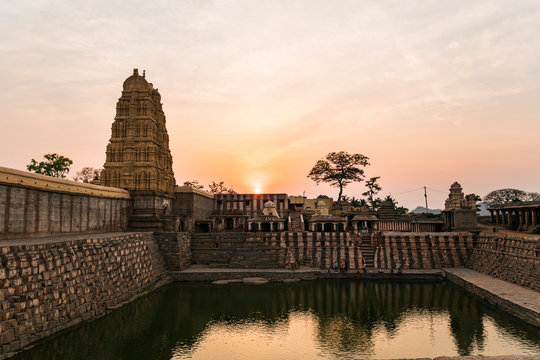 Reflexion in pond of ancient Virupaksha Temple dome at awesome sunset