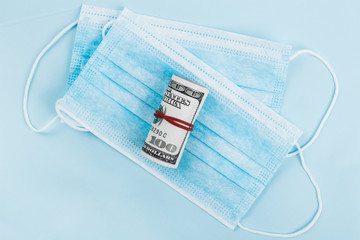Sale of medical masks. Medical mask with money on blue background. Coronavirus concept. 2019 nCoV.