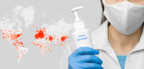 On the coronavirus online map background is a hands sanitizer holding by doctor in a protective mask and blue gloves. Concept of health care, flu virus and pandemic prevention.