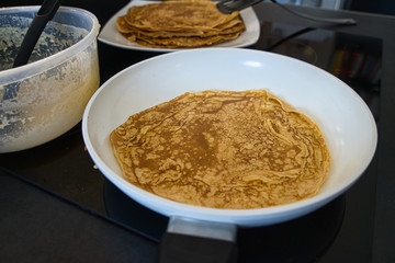 Dessert Nachspeise Vollkorn Crepe Pfannkuchen beim braten in einer weißen Pfanne mit Rührschüssel