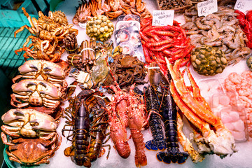 Fresh crabs, lobsters. langustas and shrimps on ice in the Barcelona fish market