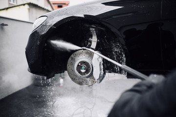 Man washing car using high water pressure, car detailing, preparation for car polish.