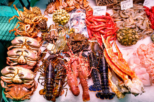 Fresh crabs, lobsters. langustas and shrimps on ice in the Barcelona fish market