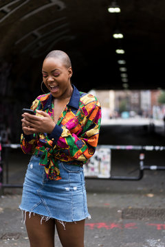 Portrait of a afro woman using the mobile phone on the street