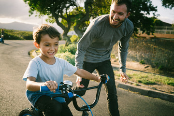 Dad teaching son to ride a bike