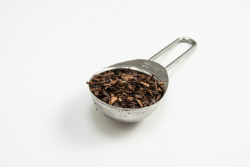 Toasted Erva-Mate into a measuring spoon.