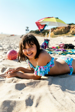 Little girl lying on the beach