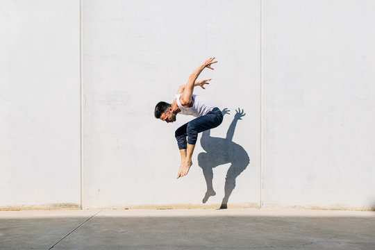 A dancer dancing in front of a concrete wall