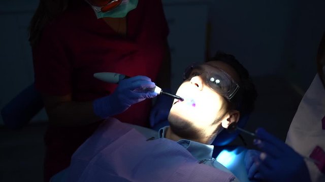 Footage of Two Female Dentists Working with Dental Polymerization Lamp in Oral Cavity.