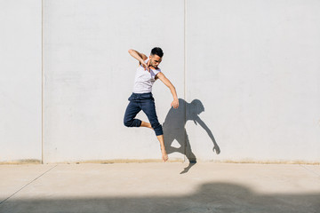 A dancer dancing in front of a concrete wall