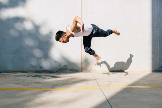A dancer dancing in front of a concrete wall