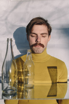 Young man with eyes closed sitting at table
