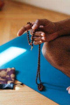 Adult unrecognizable african american man meditating at home afr