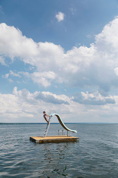 Child Playing on Floating Dock Slide At Lake