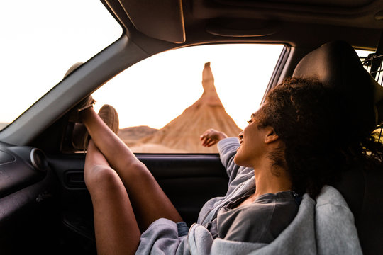 Young woman very relaxing in the passenger seat, enjoying the majestic view of Bardenas.