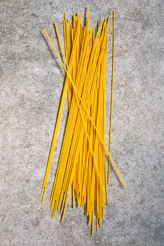 Close up of raw spaghetti arranged on a concrete bench