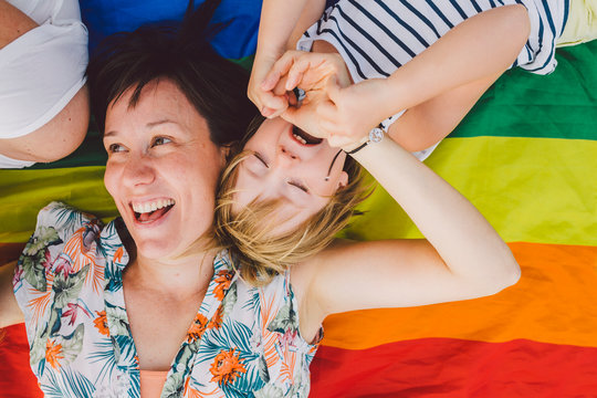 Mom and daughter having fun while lying over a lgbt flag