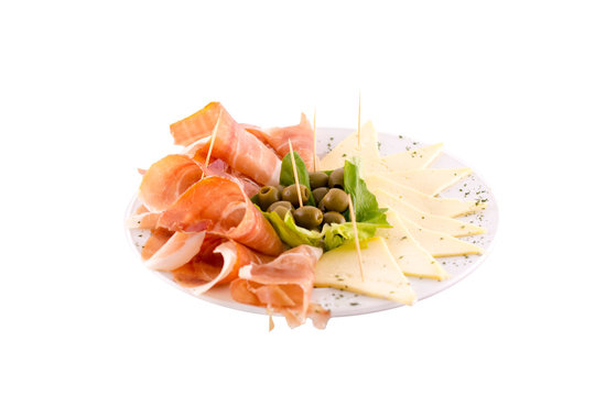 Dried meat (prshut), white cheese and green olives. Served on a white plate. Photo taken on a white background. Dish of Montenegrin cuisine. Suitable for the restaurant menu.