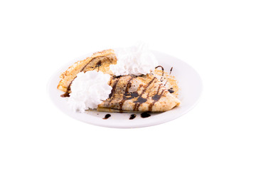 Pancakes with chocolate, butter cream and nuts. Served on a white plate, melted on a white background. The photo is suitable for feeding mei restaurant. Dish of Montenegrin cuisine.