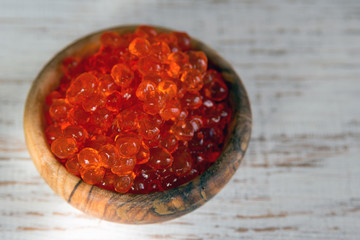 Red vegan caviar from kelp seaweed in a wooden bowl on a white background. Valuable and useful product for a healthy diet. Superfood. Close-up
